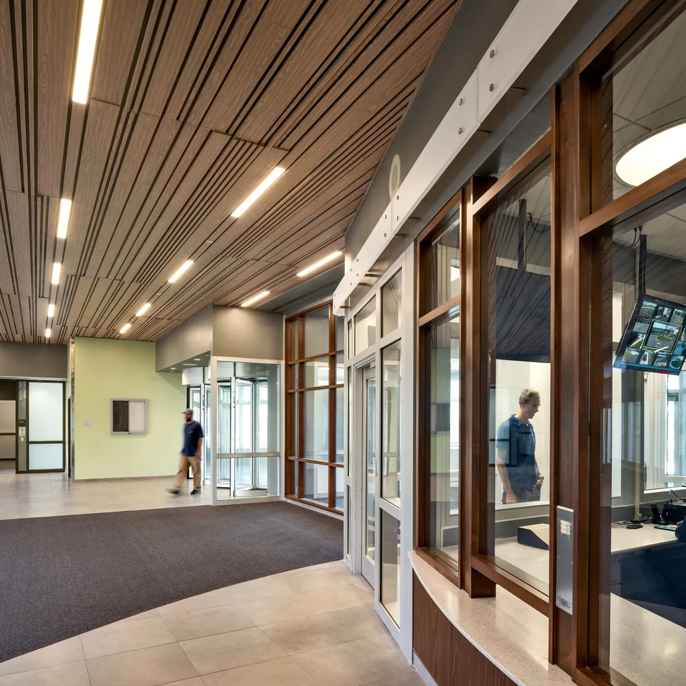 Inpatient corridor with a timber slatted ceiling and glazed views into day spaces