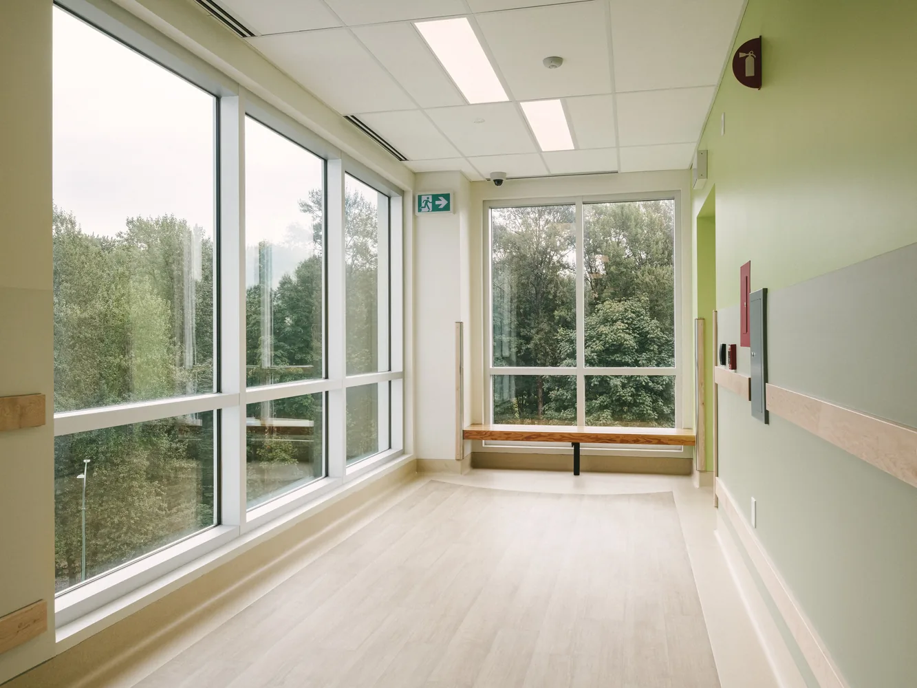 Corridor with a timber bench beneath a full-height glazed wall